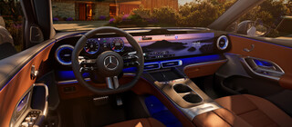 Cockpit des Mercedes-Benz GLC mit digitalem Display, Lederinterieur und blauer Ambientebeleuchtung vor moderner Hauskulisse. | © Mercedes-Benz AG